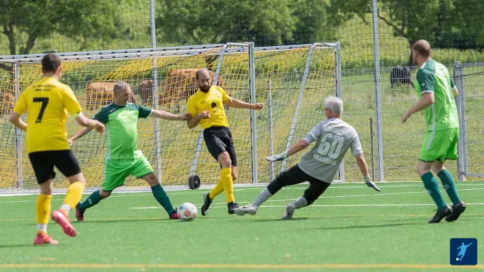 Zwei Mannschaften spielen Fußball auf einem Kunstrasenplatz.